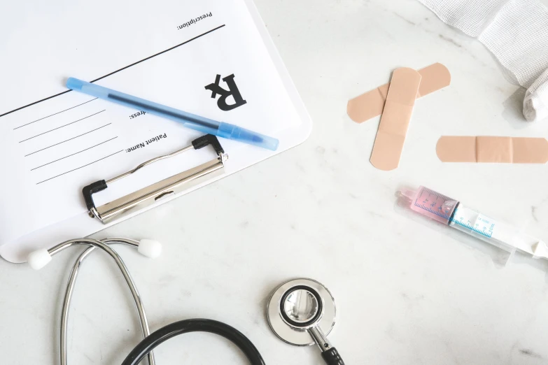 a clipboard, stethoscope and a doctors note on a table