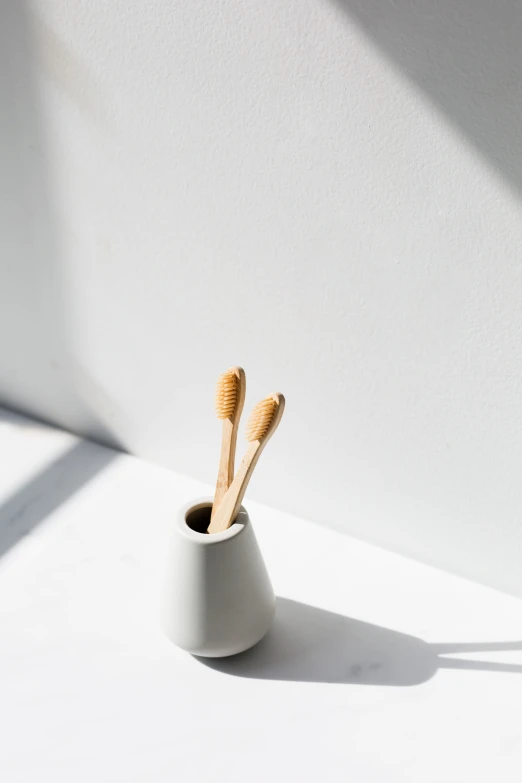 the toothbrushes are sitting inside of a vase