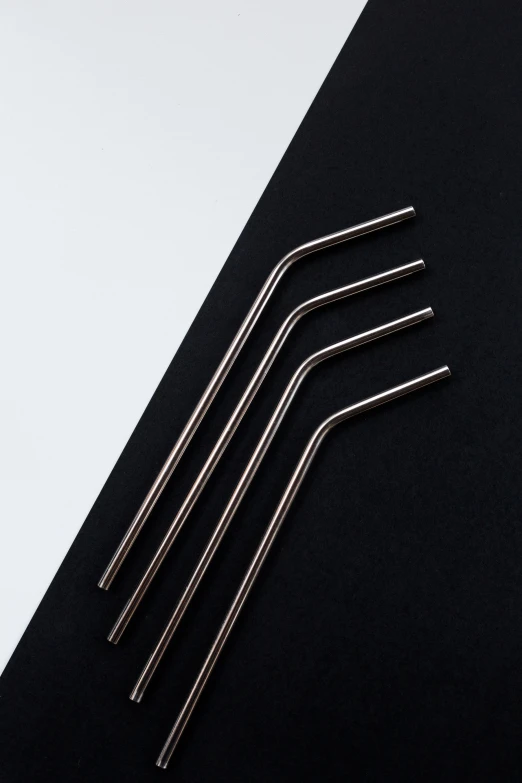 a black table with four thin metal straws