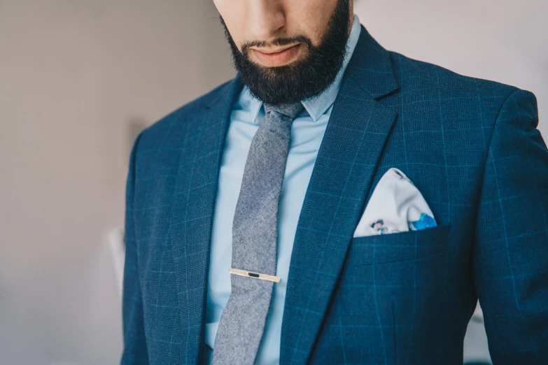 a man wearing a suit and tie holding his hands in pockets