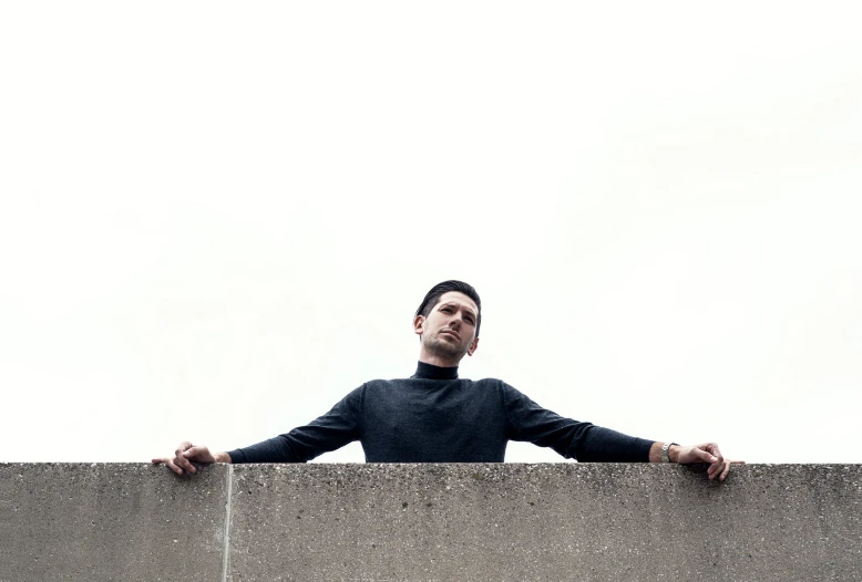 a man leans over a large ledge