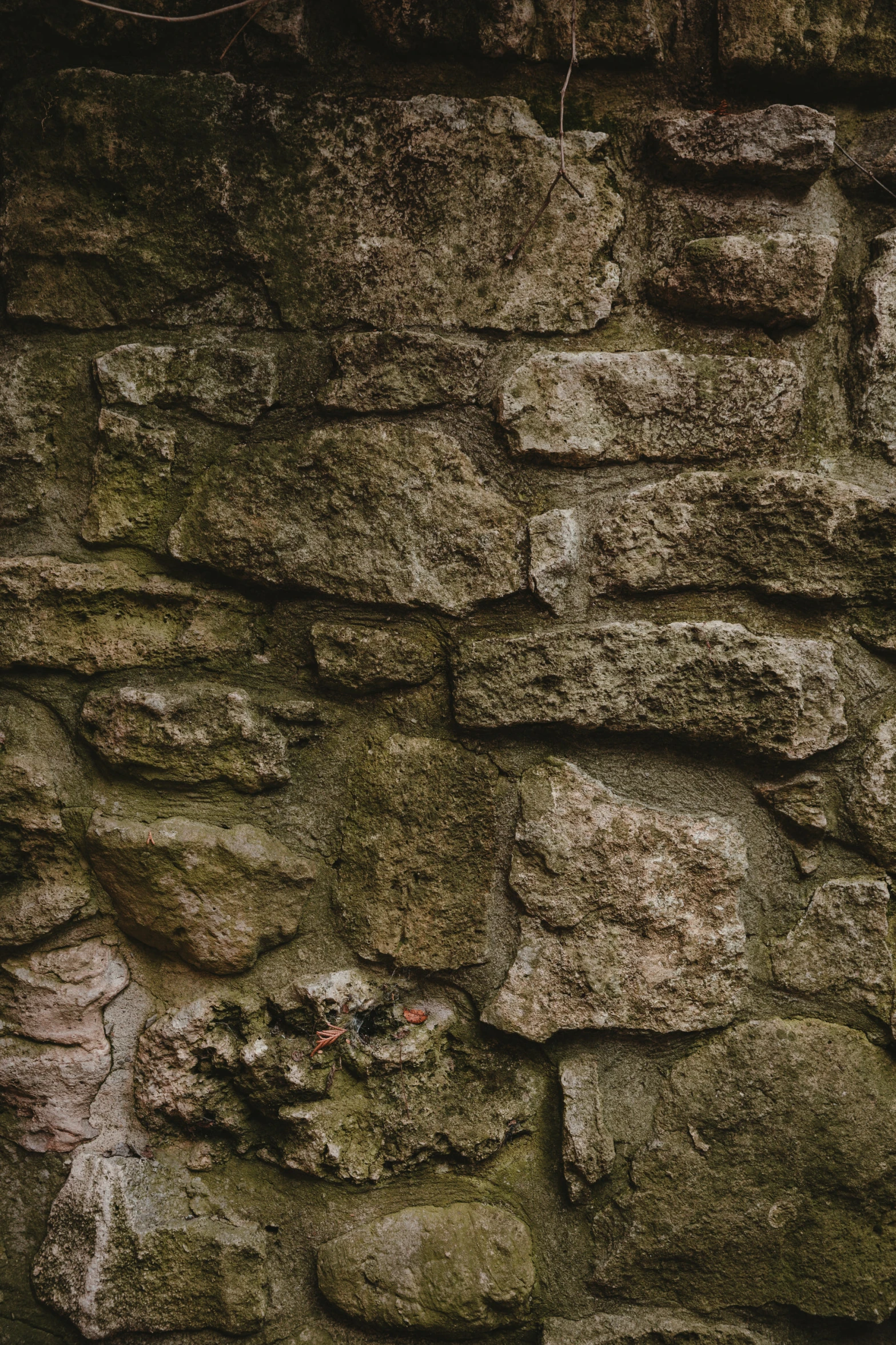 a red fire hydrant sitting in front of an old stone wall