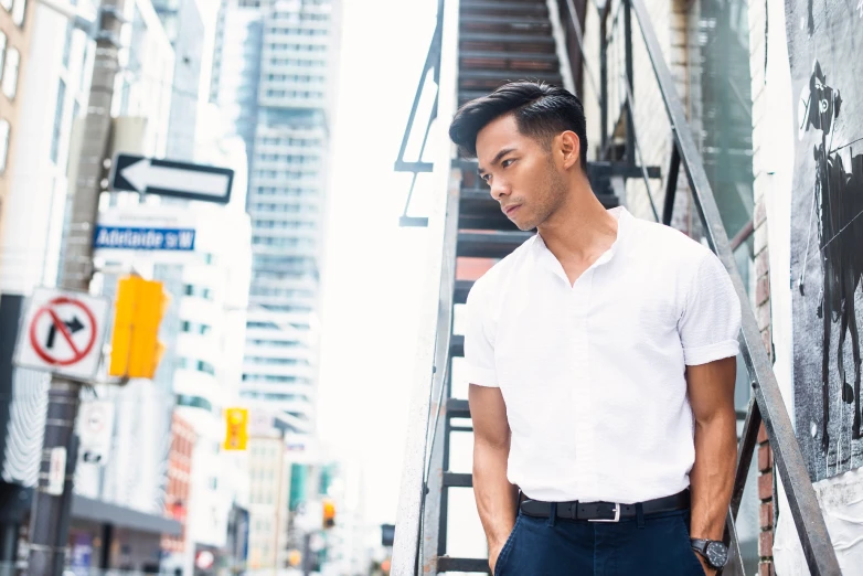 a man leans against the steps in a city