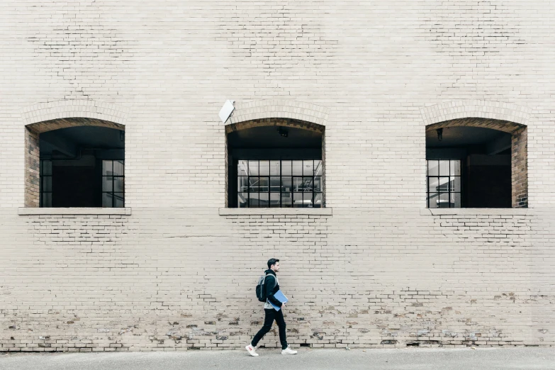 a man walking on the sidewalk next to a building