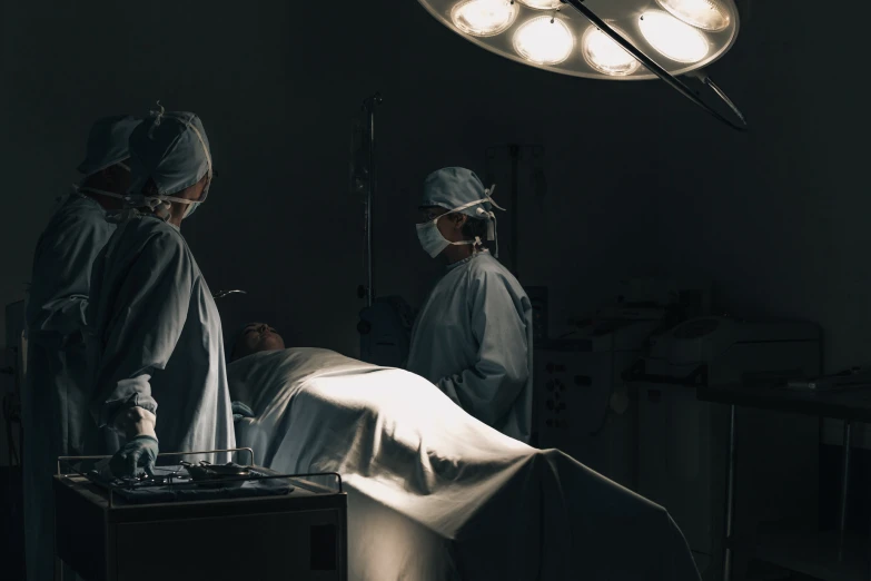 two doctors performing  on a woman in a hospital bed