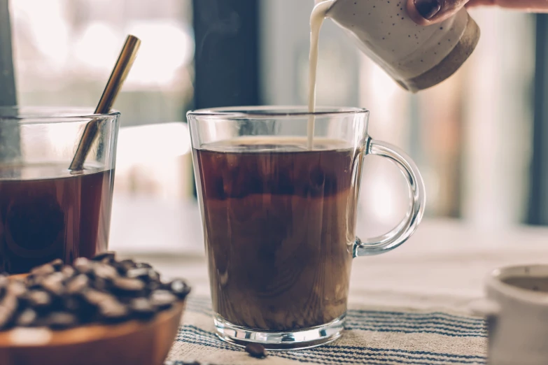 there is a coffee being poured into a glass