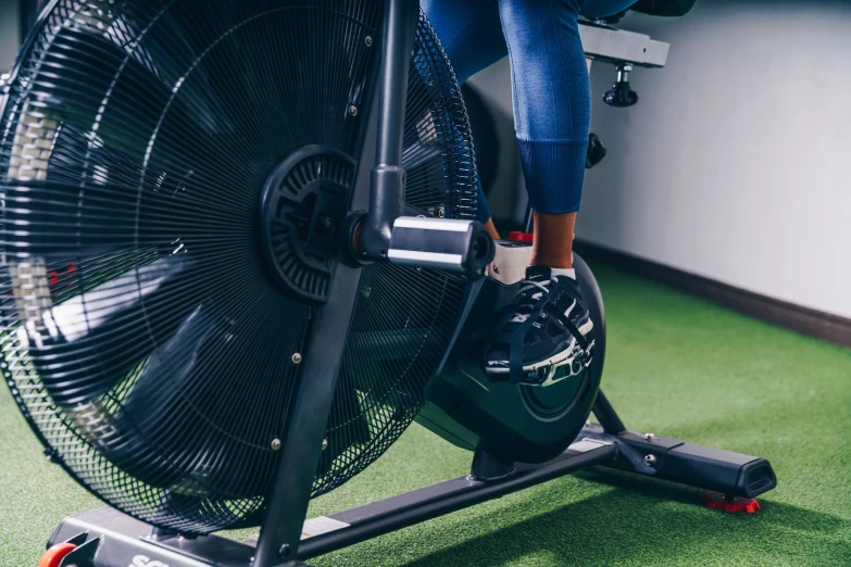 a woman riding an exercise bike on top of green carpet