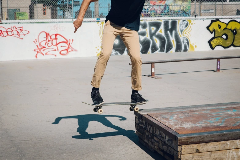 a young man riding a skateboard on top of a wooden bench