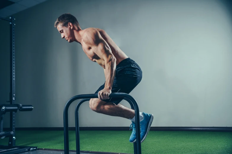 a man who is doing squats on a cross bar