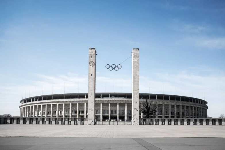 a large building with two pillars and an olympic logo