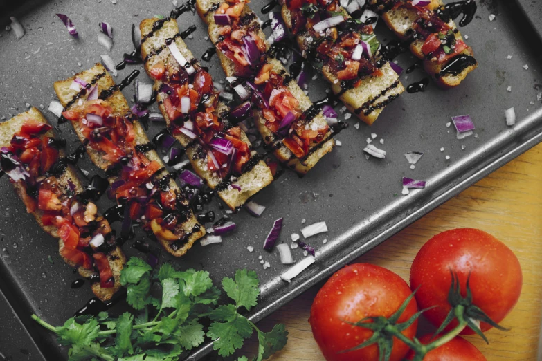 a black and white picture with tomatoes, garnishes, and bread sticks