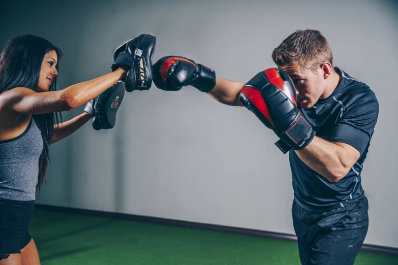 young attractive couple practicing boxing in indoor studio