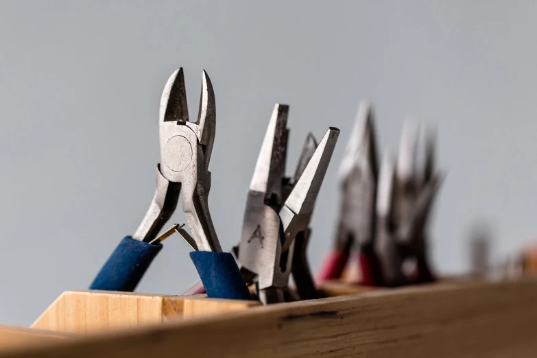 a row of pliers sitting next to a wooden box