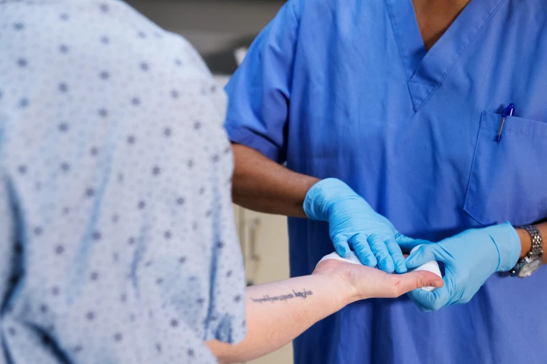 the hands of two people with surgical gloves on