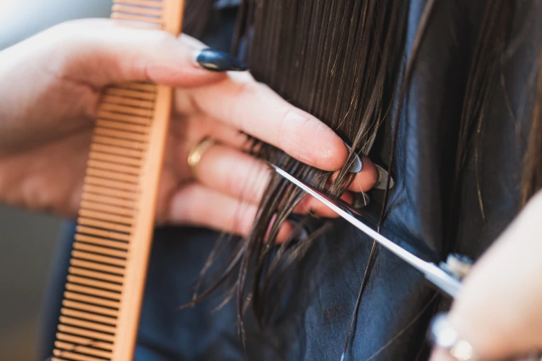 woman combing hair with scissors in front of her