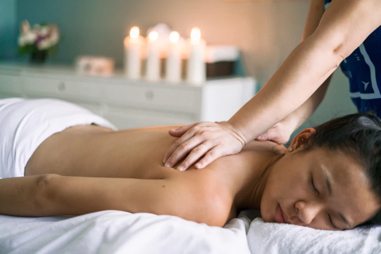 a woman getting a massage with candles lit