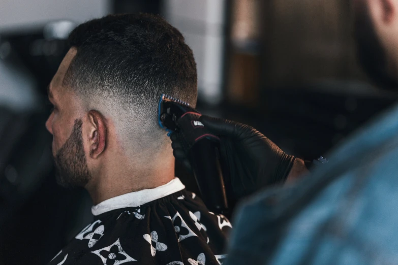 a close up of a man getting a haircut at a barber shop