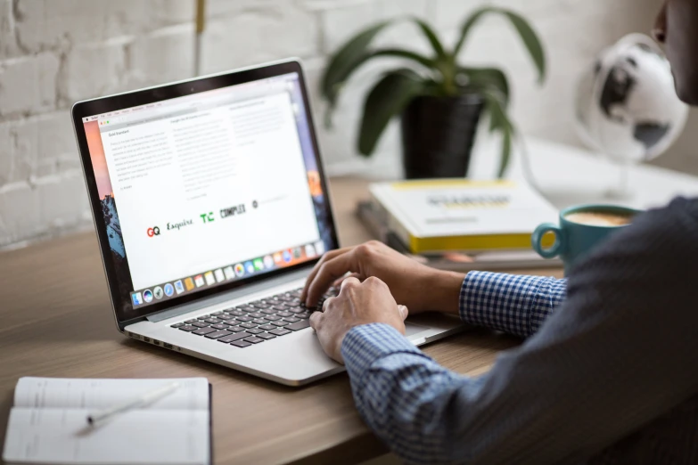 man using laptop on desk in office setting