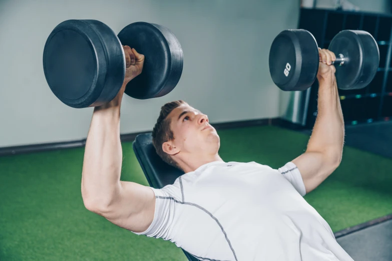 a man lifting dumbbells in the gym