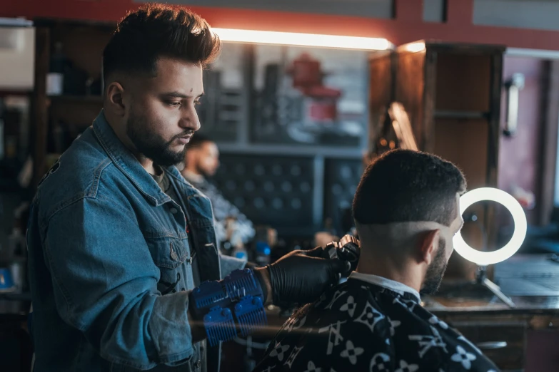 the barber is shaving the man's beard