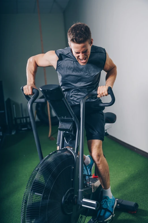 a man on an exercise bike using the trainer's hand