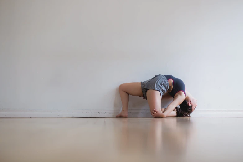 a woman is in position on the floor with her hand under her head