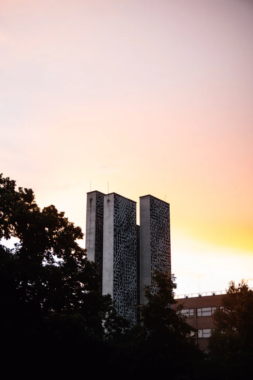 two tall buildings are sitting next to trees