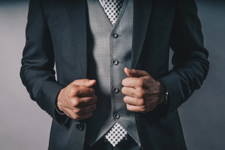 the man is wearing a gray suit with a polka dot pocket square tie