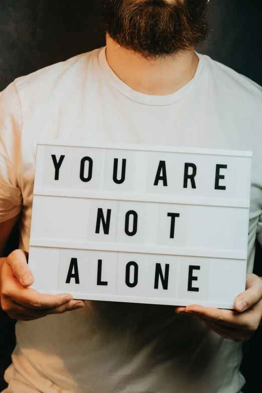 a man holding up a sign with text on it