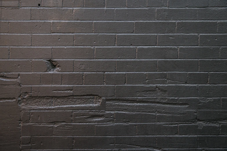 a grey brick wall with some water marks on it