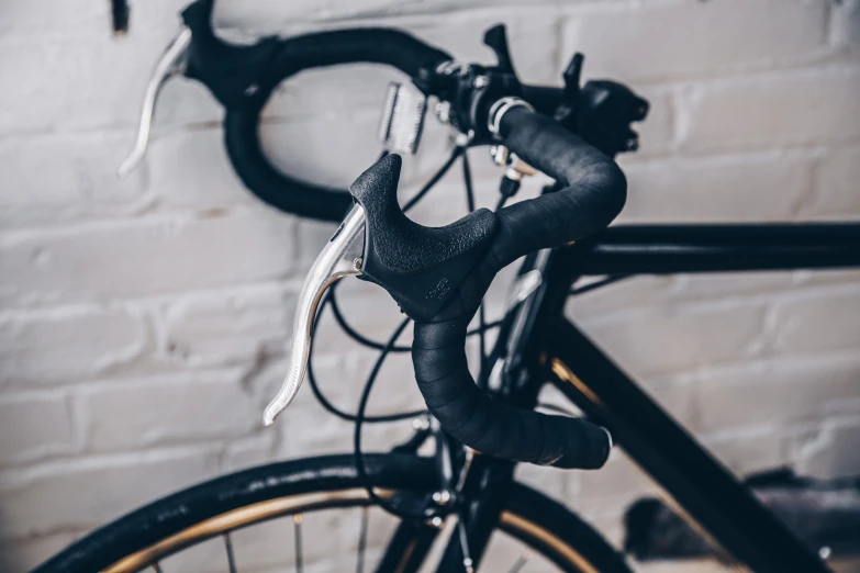 a bicycle parked against a white brick wall