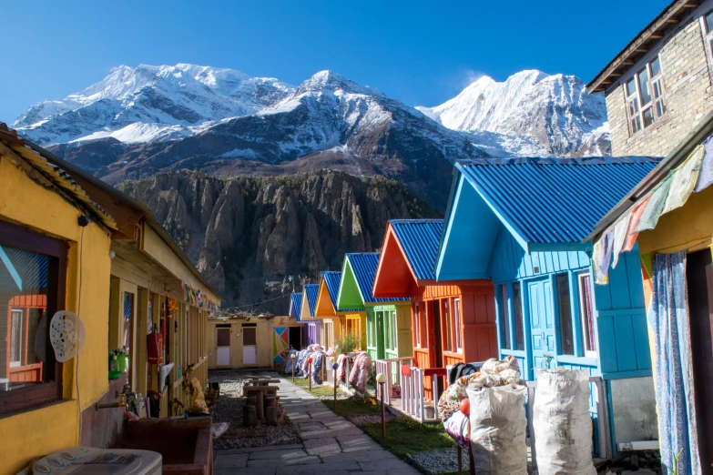 colorfully colored homes in front of snow capped mountains