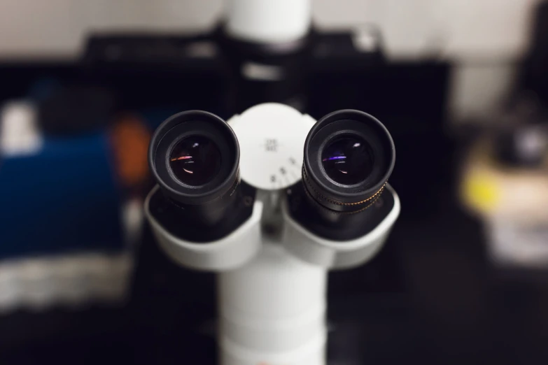 two cameras sitting on top of a white pole