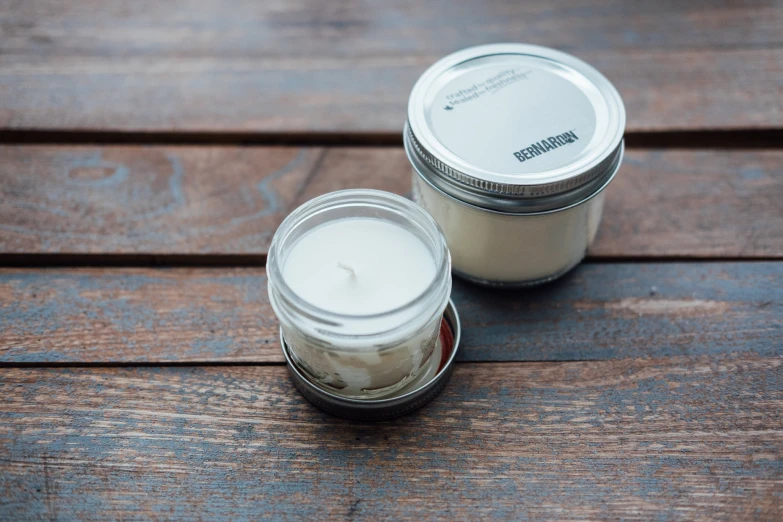 two jars sitting on top of a wooden table