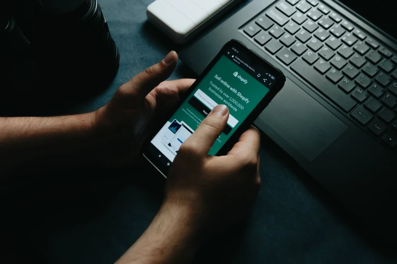 a person using their phone to read and view what's on their computer