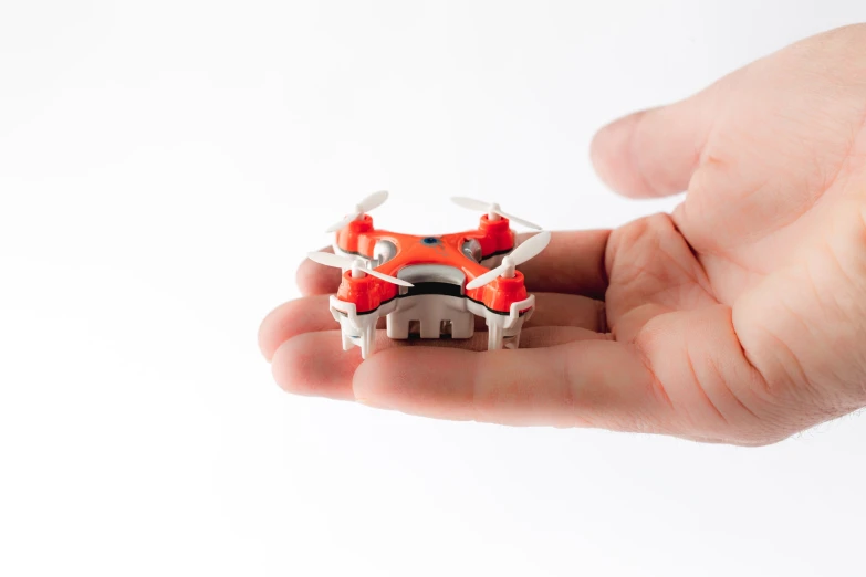 small red and white airplane model held in the palm of a person