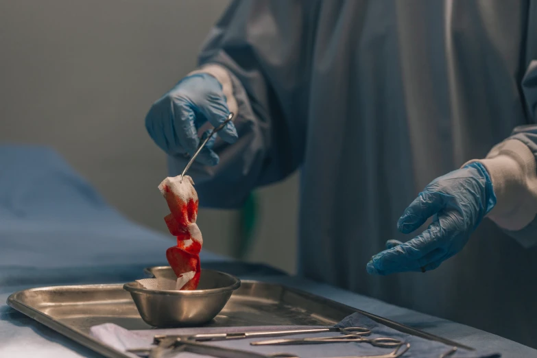 surgical worker holding toothbrush and  tooth in bowl