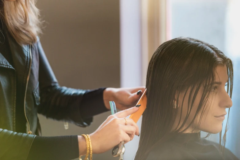 the woman is having her hair cut with a hair clip