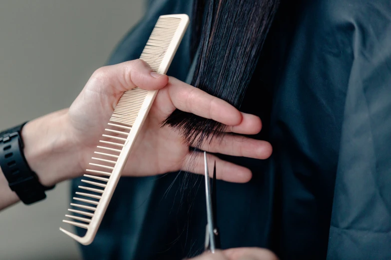the comb is being held by someone's hand while they are  their hair