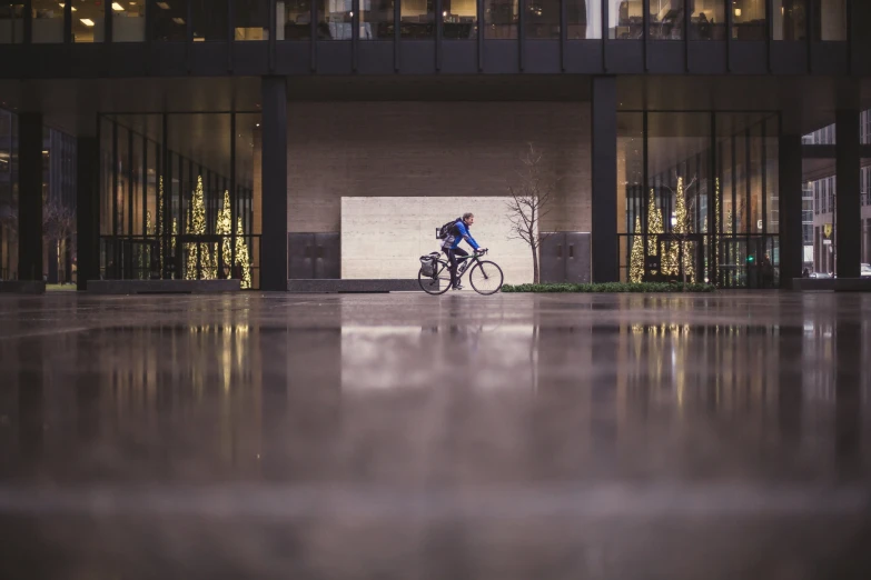 a cyclist rides his bicycle down the sidewalk in front of a building