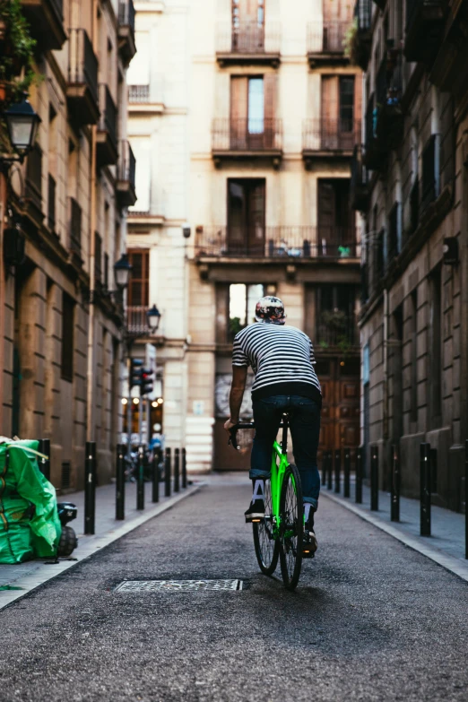 a man rides a green bike down the street