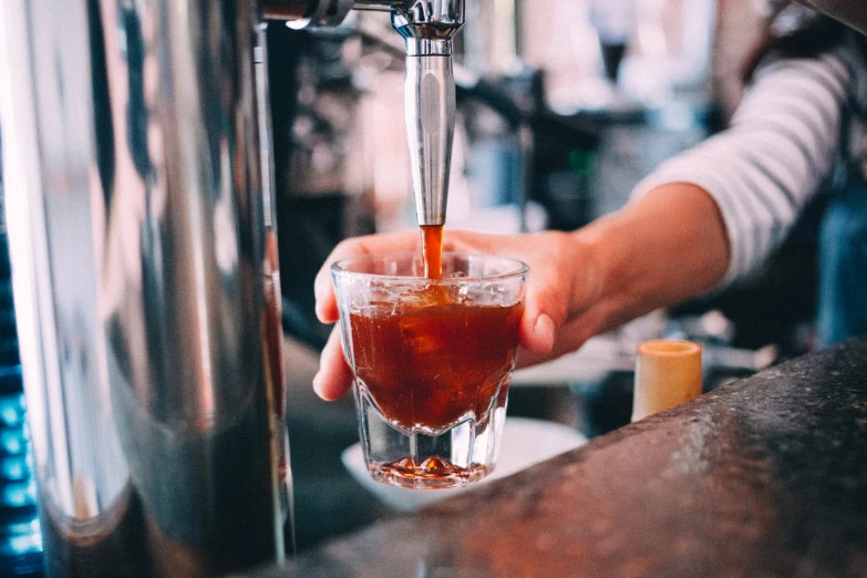 a bartender pouring a beverage in a glass