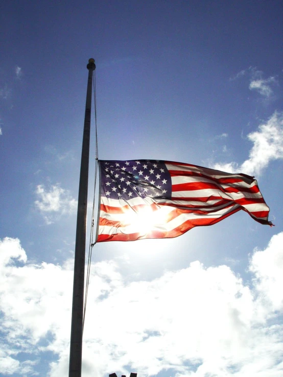 a flag waving on top of a tall pole