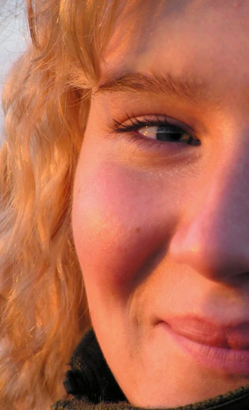 a girl with blue eyes is smiling for the camera