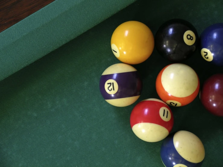 eight ball set with number nine displayed on green cloth