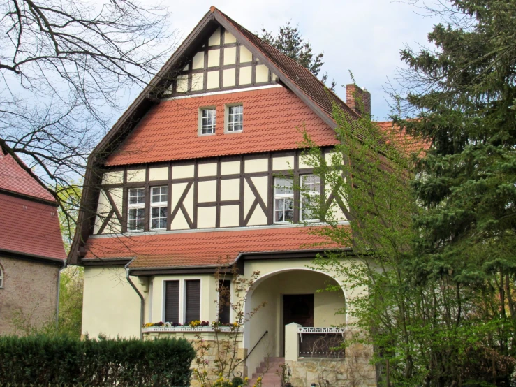 the two story house has red shinding and black shutters