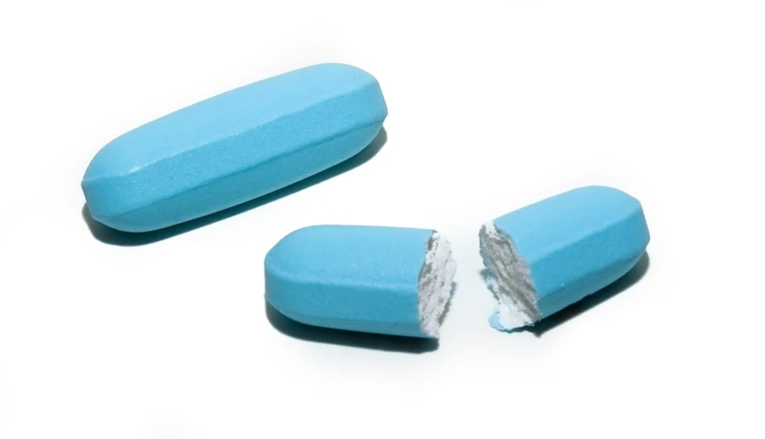 two blue pill like objects are seen split apart