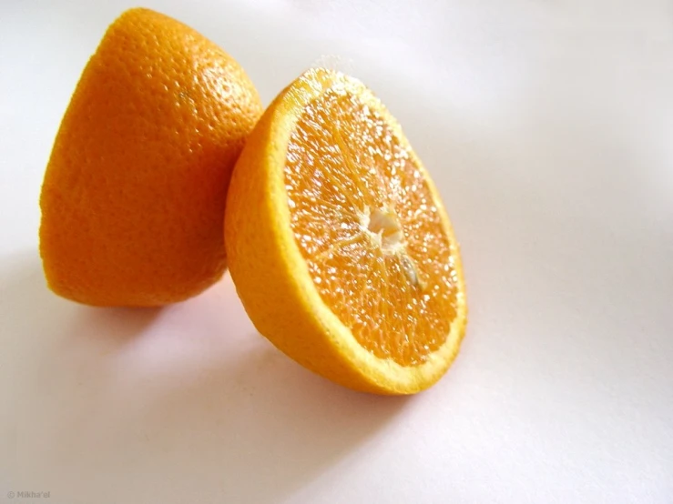 two oranges are shown in closeup on a white surface