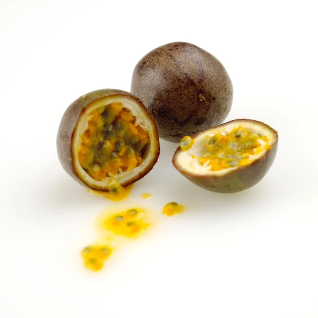 a whole and sliced passion fruit are lying on the floor