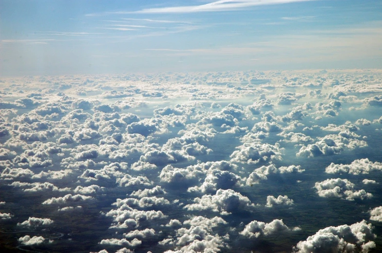 the view out of an airplane window shows many white clouds